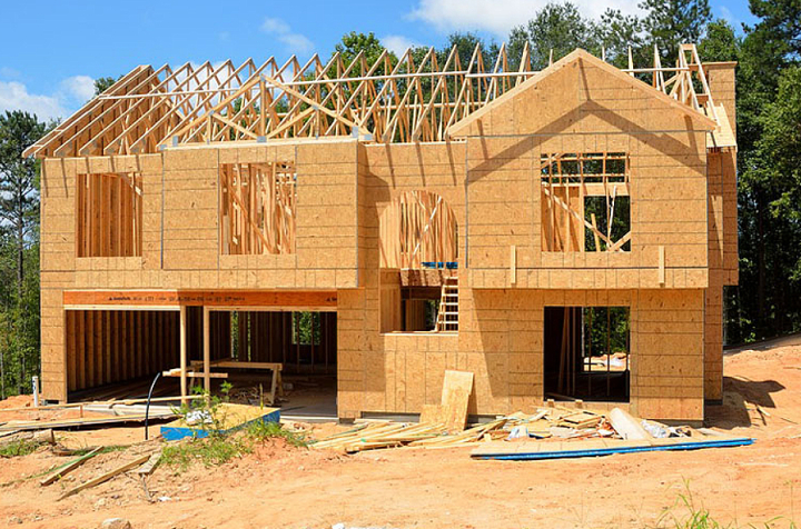Zimmermannsarbeit am Rohbau eines zweistöckigen Holzhauses im Mainviereck